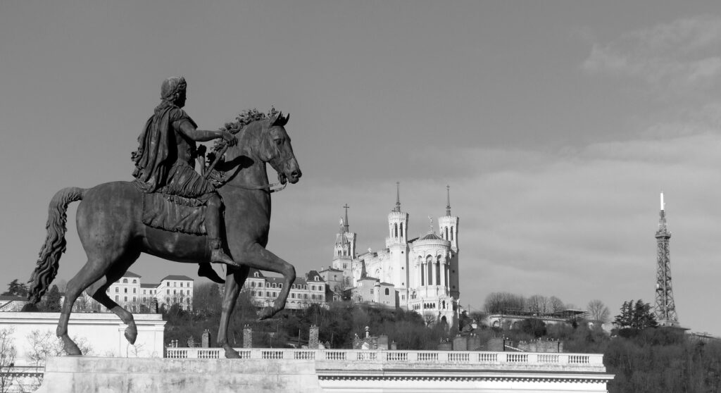 Monochrome image of equestrian statue with Notre-Dame de Fourvière in Lyon.
